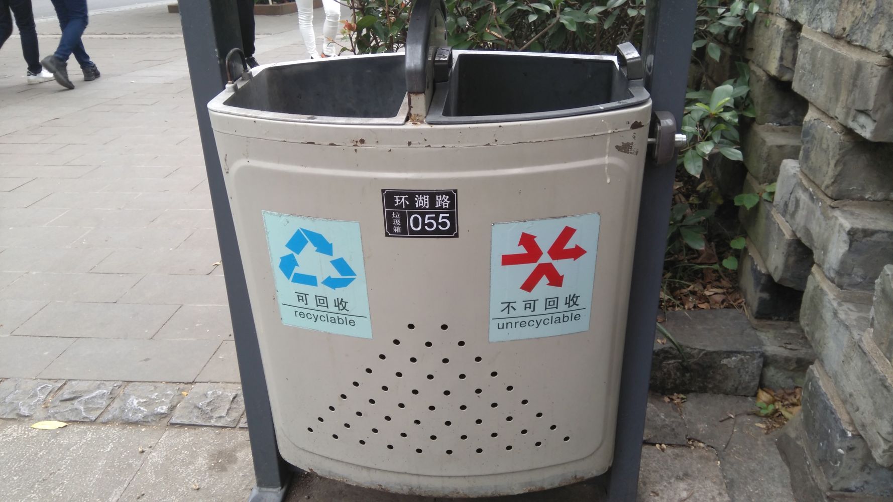 A bin that says unrecyclable with three red arrows pointing outward